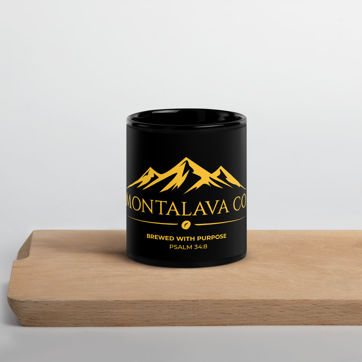 Montalava Co. black 11 oz mug with gold Brewed With Purpose design on a wood table